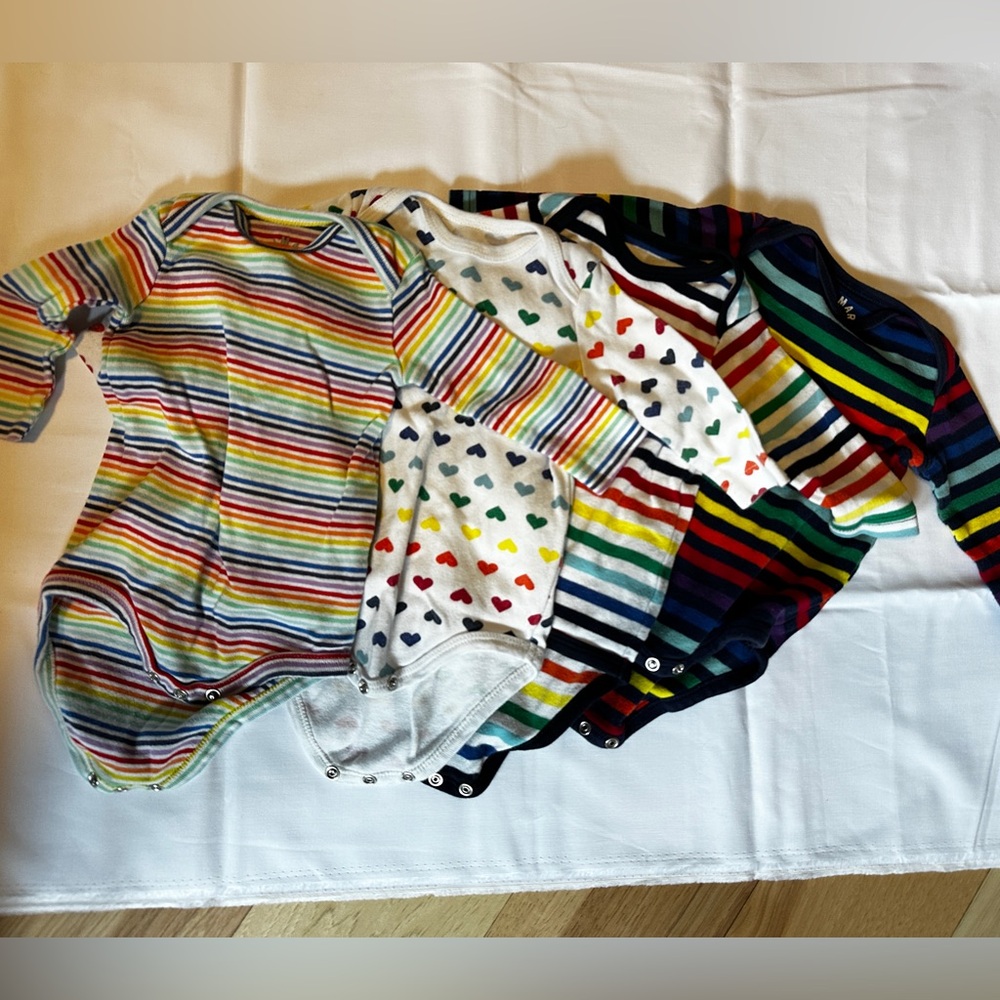 Four 0-3 primary rainbow onesies